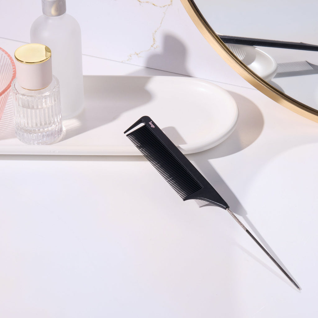Black metal pin-tail teasing comb on a vanity tray 