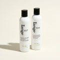 L'ange Frizz Care Shampoo and Conditioner bottles on a beige background
