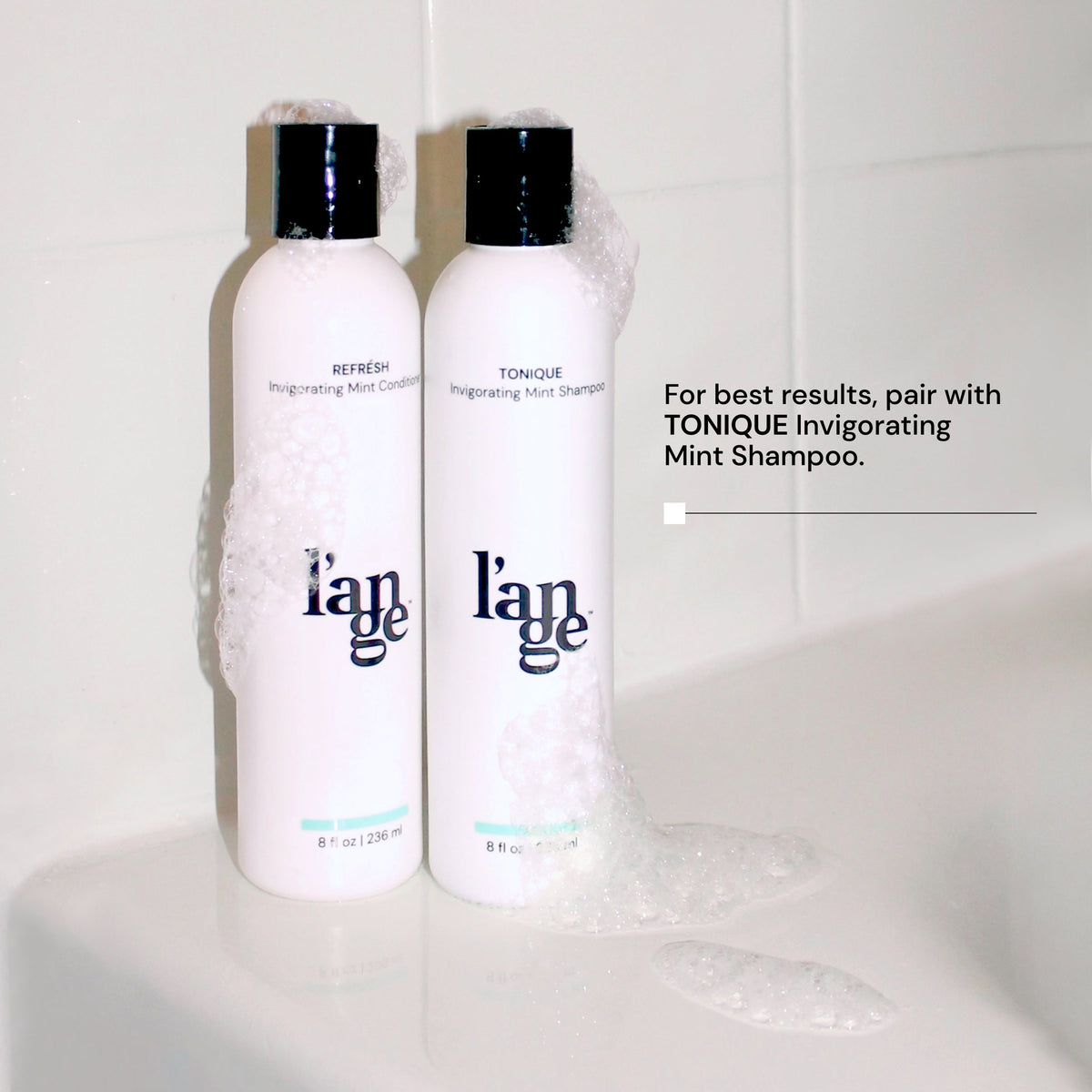 Two bottles of shampoo and conditioner with soap over them with copy saying, for best results, pair with Tonique Invigorating Mint Shampoo.