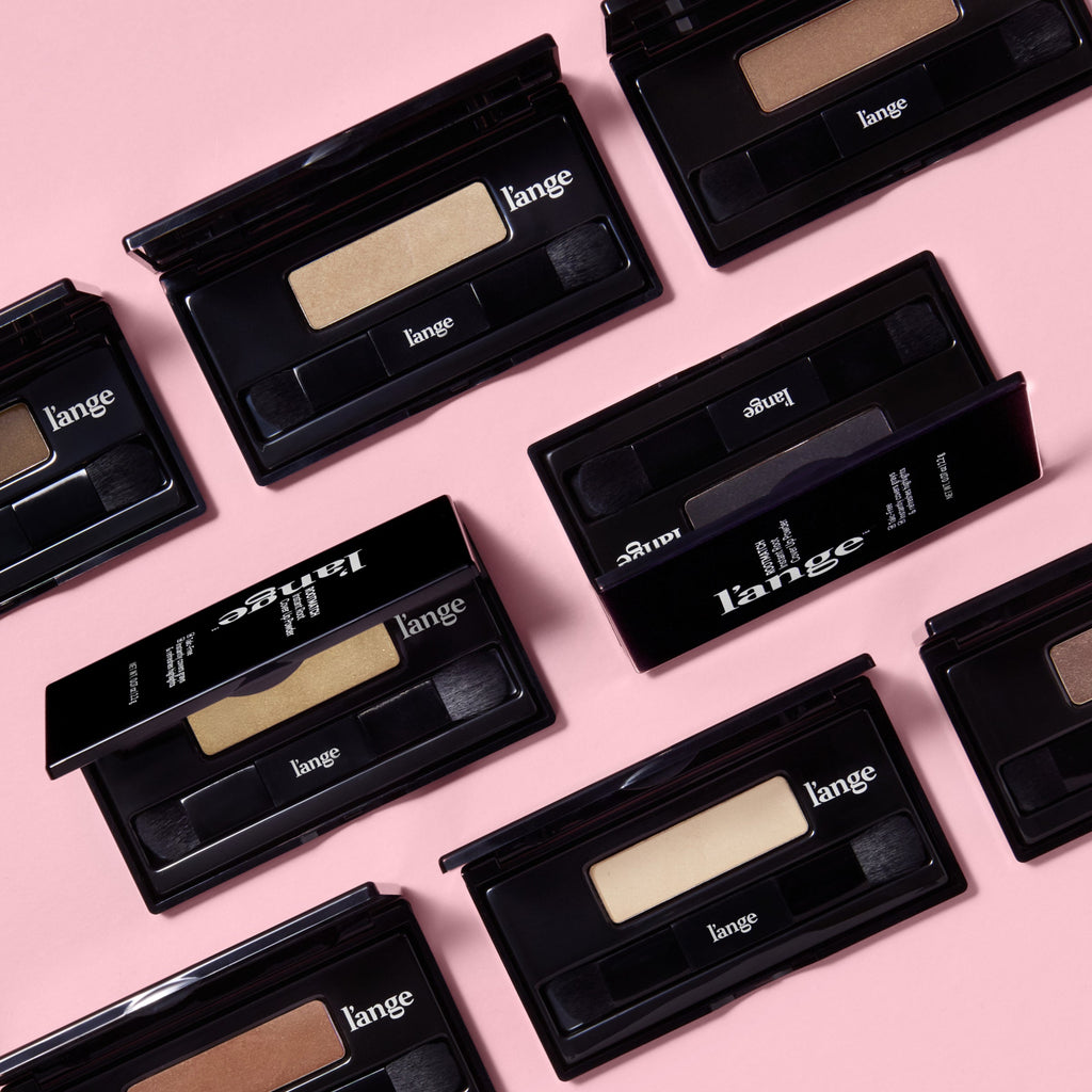 Assorted l’ange RootMatch compacts and boxes arranged on a pink background, showing multiple shade options