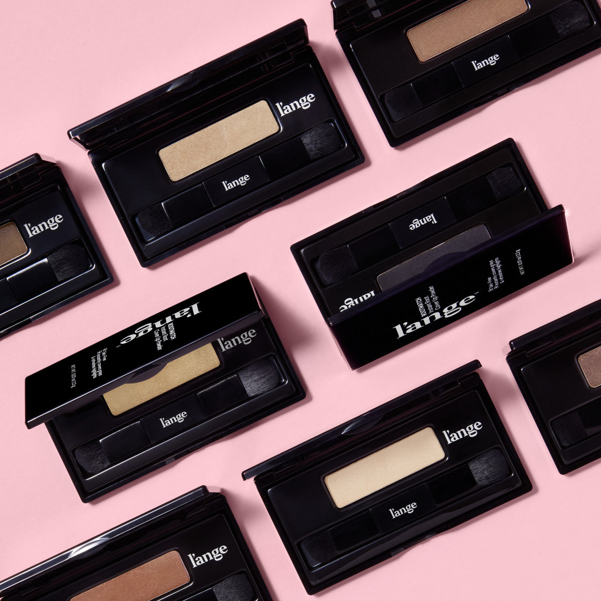 Assorted l’ange RootMatch compacts and boxes arranged on a pink background, showing multiple shade options