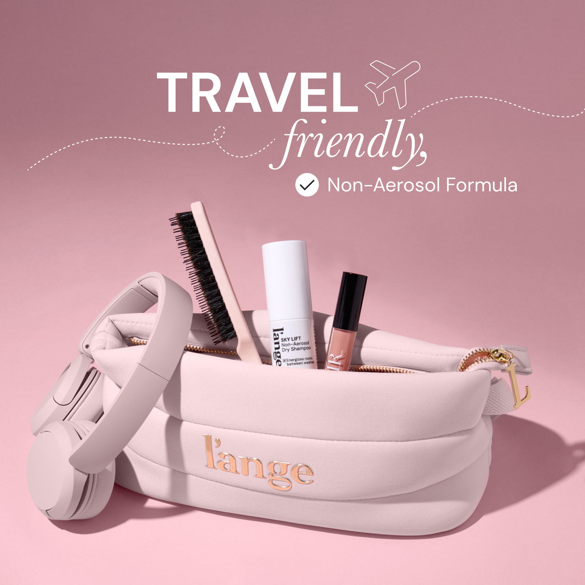 A travel-friendly scene featuring a L'ange branded pink makeup bag filled with a hairbrush, lip gloss, and a bottle of Sky Lift Dry Shampoo. Text reads "Travel friendly, Non-Aerosol Formula"