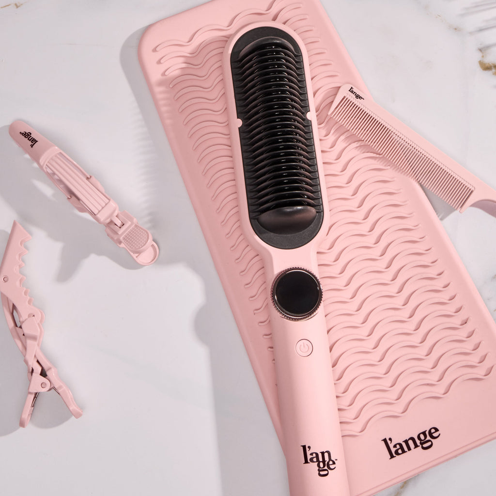 Smooth-It on a vanity with a heat-resistant mat and hair clips and a comb.  