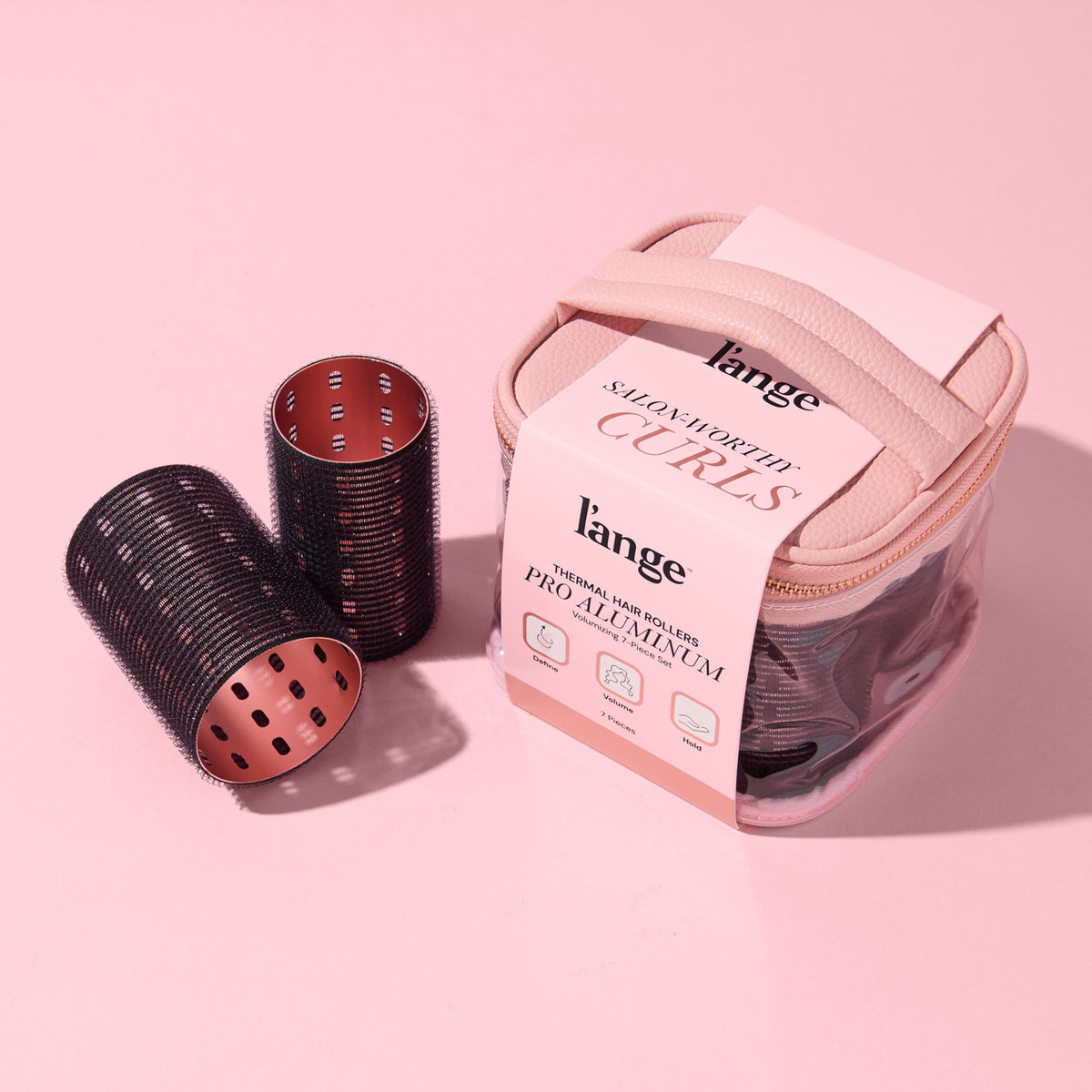A collection of black thermal hair rollers and case, arranged on a pink background