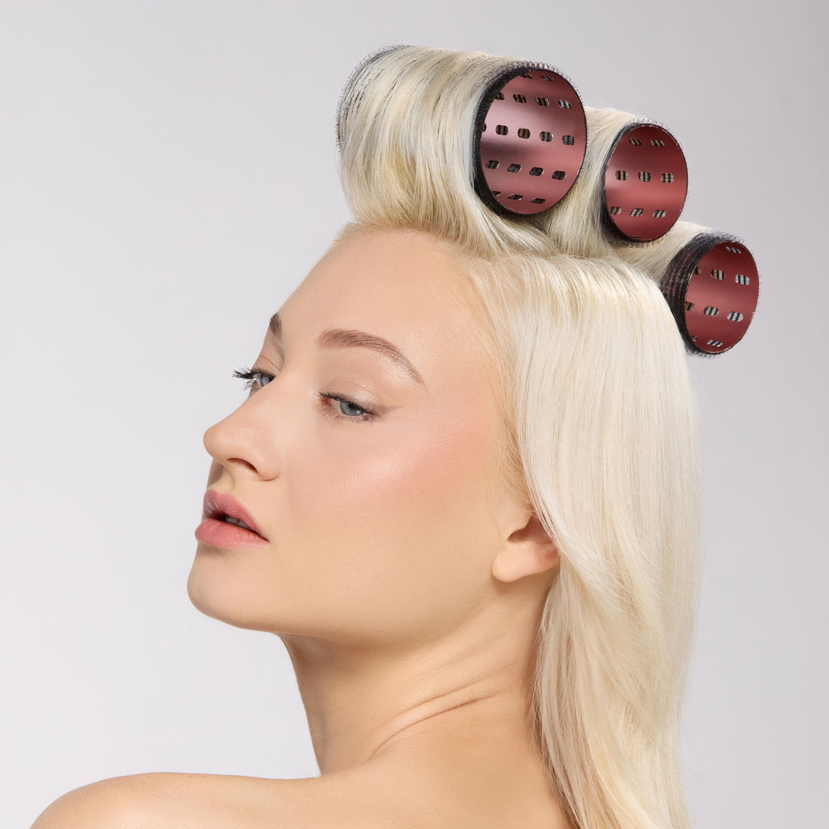 model with thermal hair rollers secured at the crown of her head