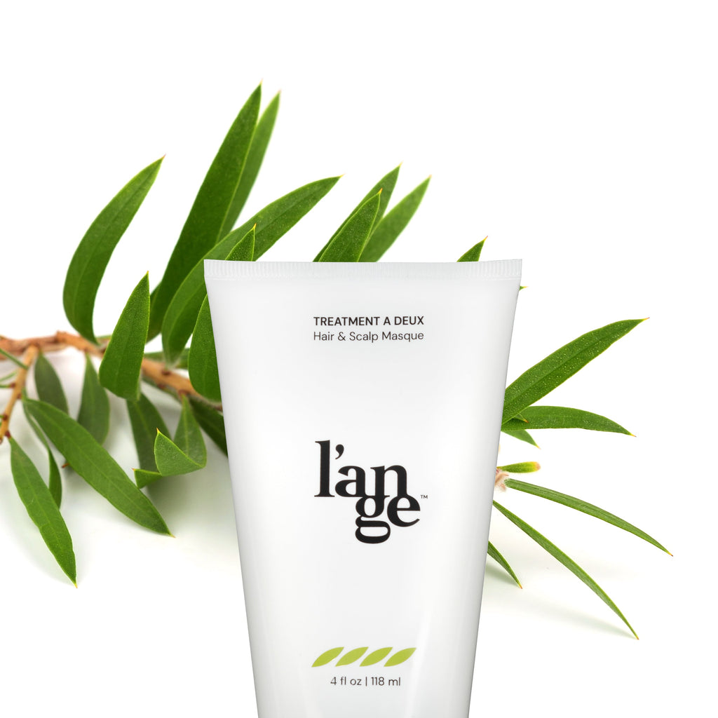White bottle of Treatment A Deux Hair & Scalp Masque with green leaf in background